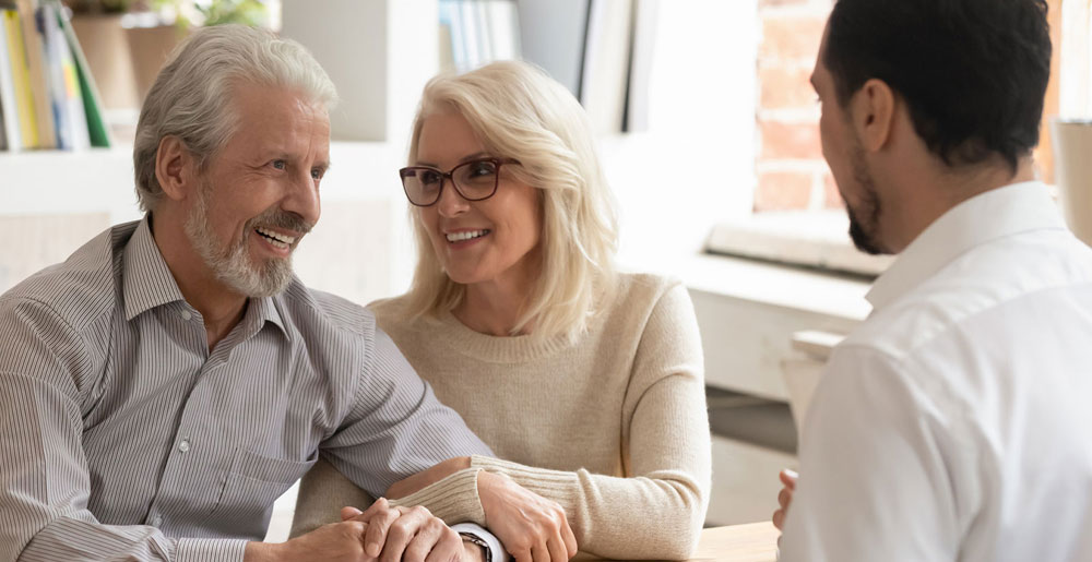 Older couple meeting with a financial professional at a desk.