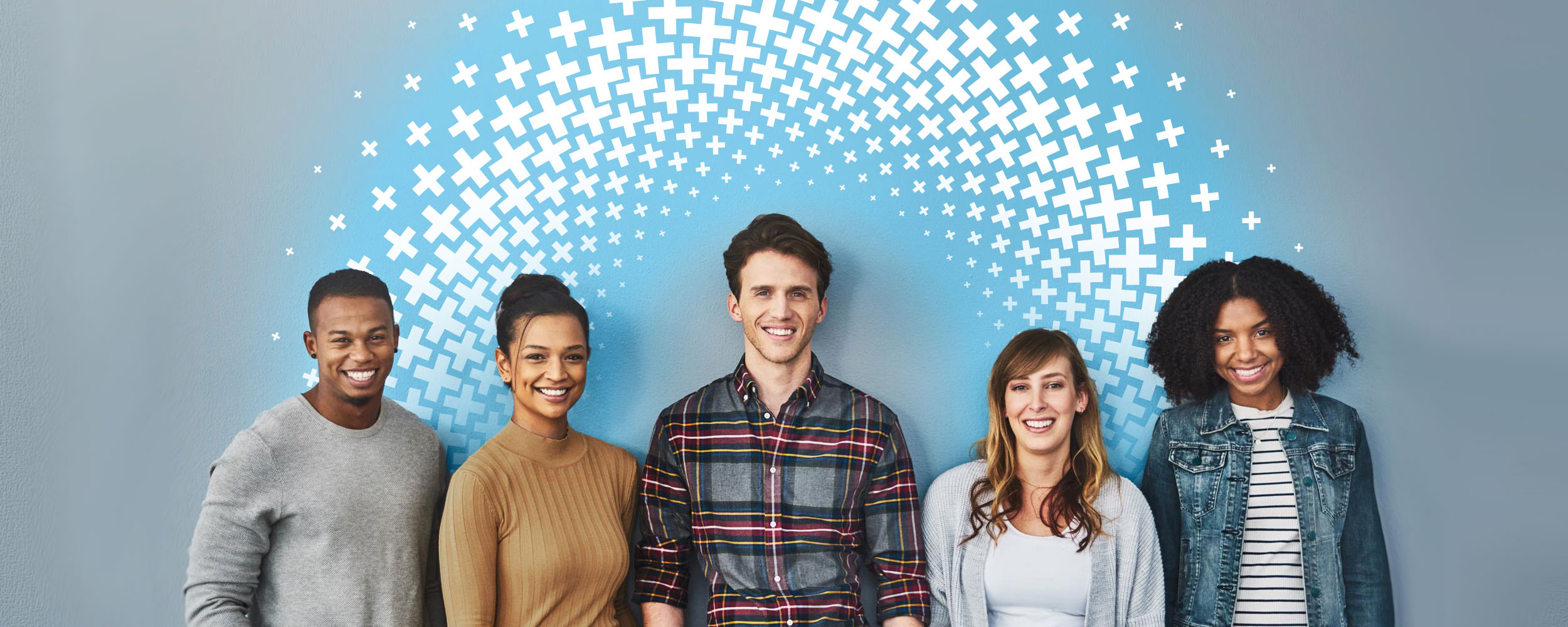 Five adult friends stand in front of a blue wall.