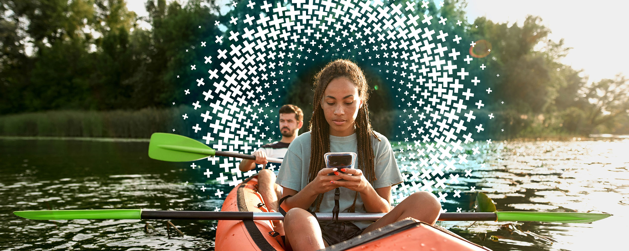 Woman looks at her phone while kayaking.