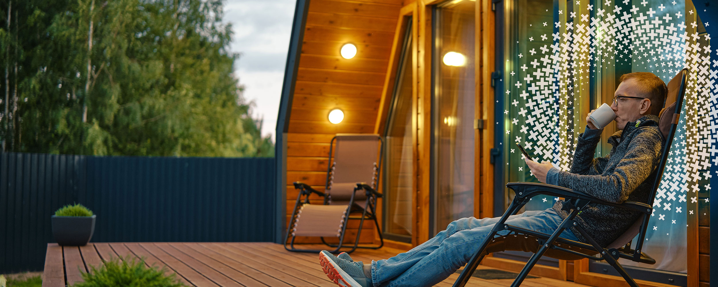 Man sitting on his deck, drinking a hot drink.