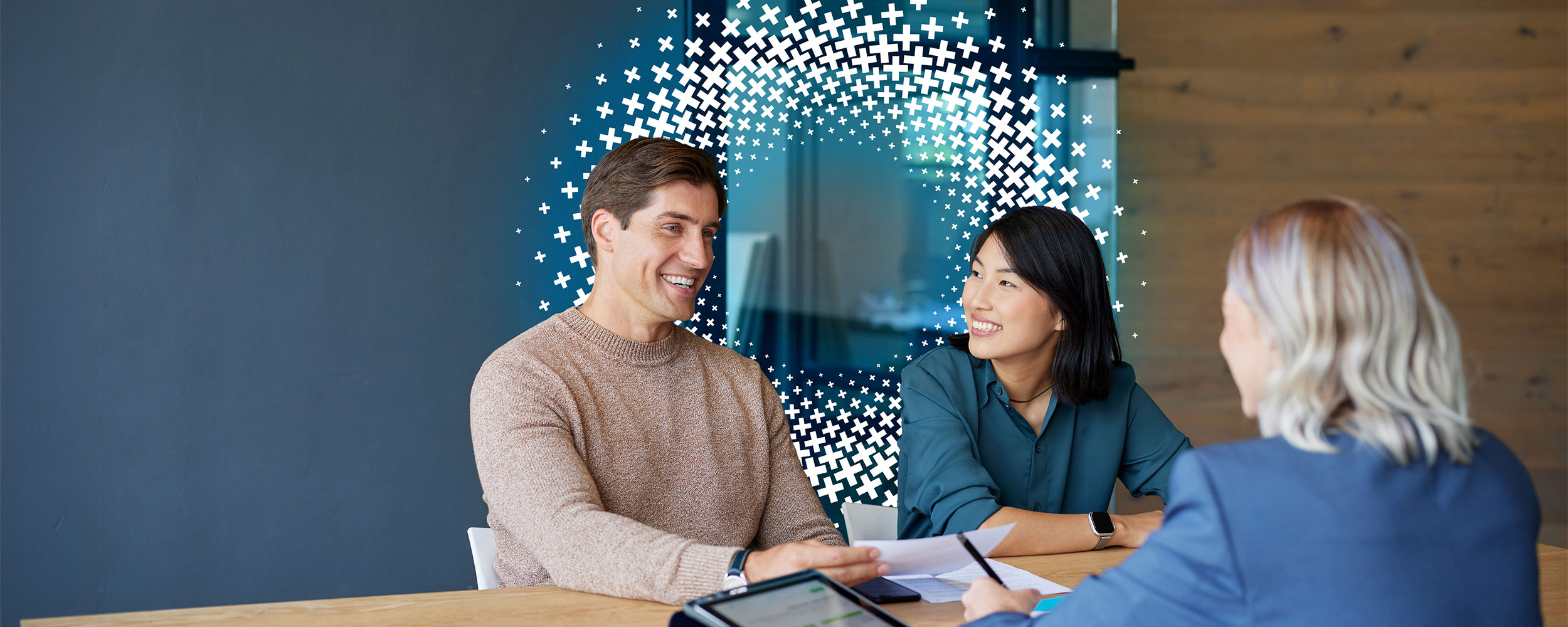 Couple meeting with a financial professional to review documents and discuss their finances.