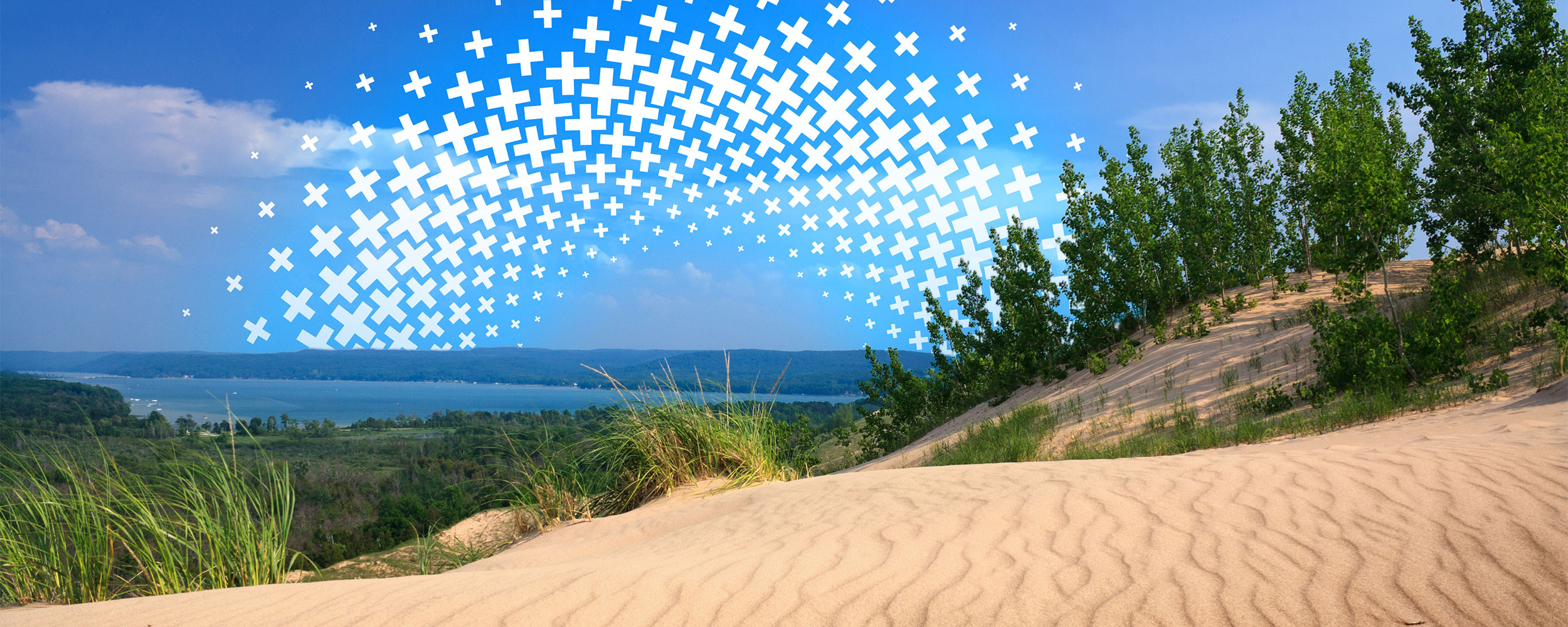 Rolling sand dunes over a lake.