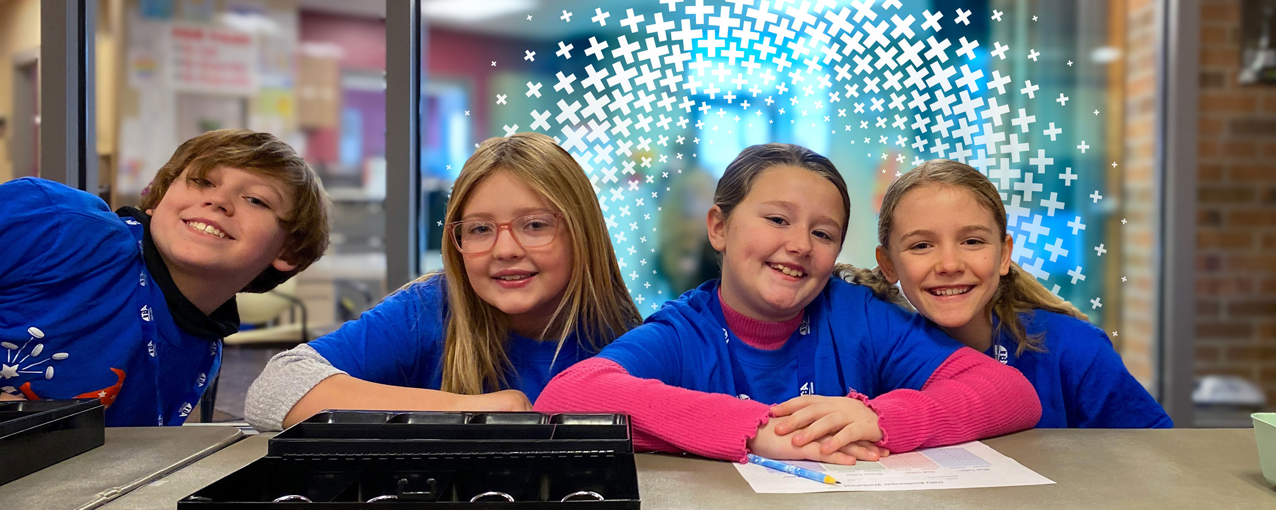 Four kids smiling while volunteering.