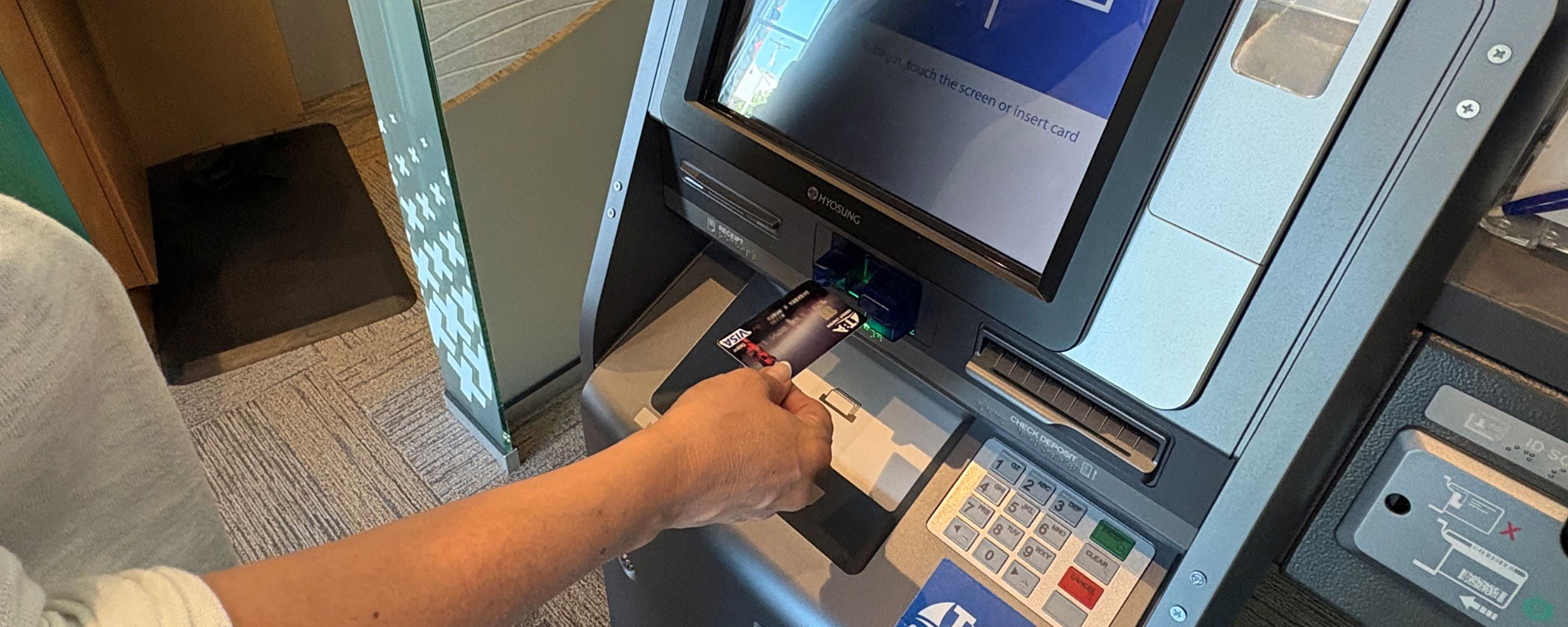 Someone uses an ATM with their debit card.