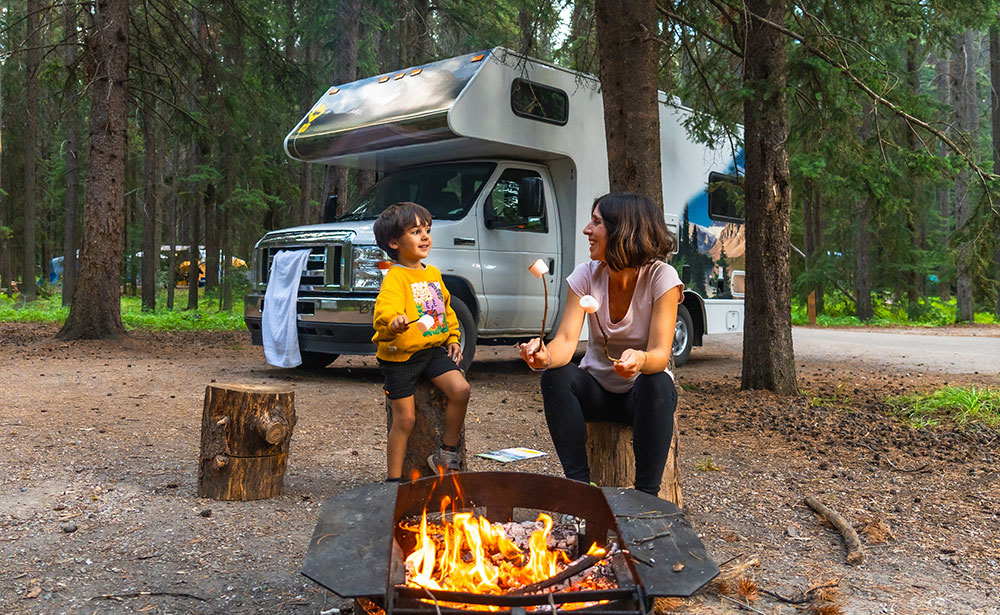 615-rv-2253615804 Mother and son roasting marshmallows over a fire while at a campground.
