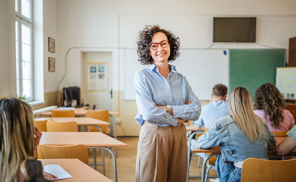 female teacher standing confidently in the middle of her classroom