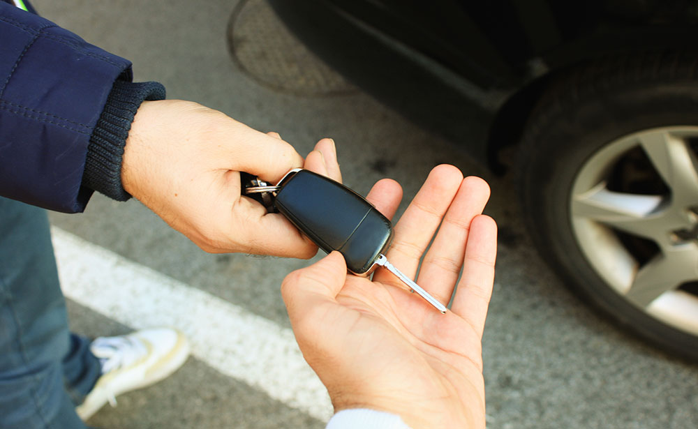 One person receiving from another the keys to a new car