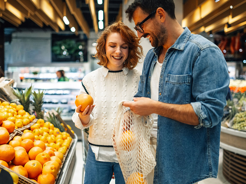 750-everydayspending-2186420837 Couple shopping for fresh produce together in a grocery store.