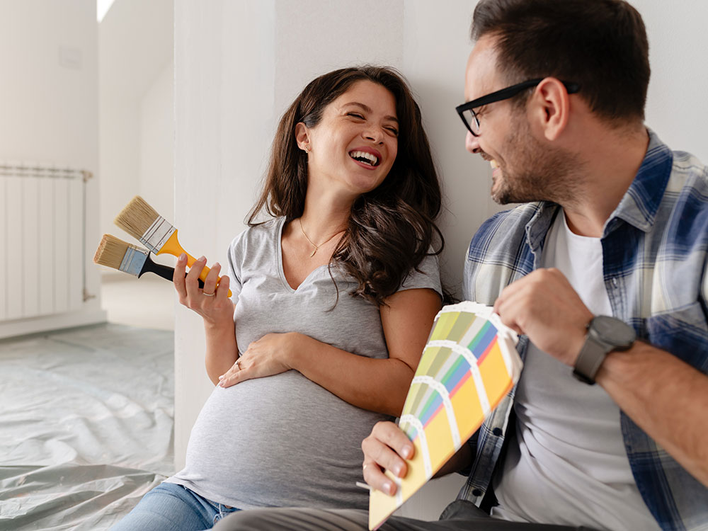 750-flexible-financing-1955784554 Couple sitting together with paintbrushes and color samples while planning a home improvement project.