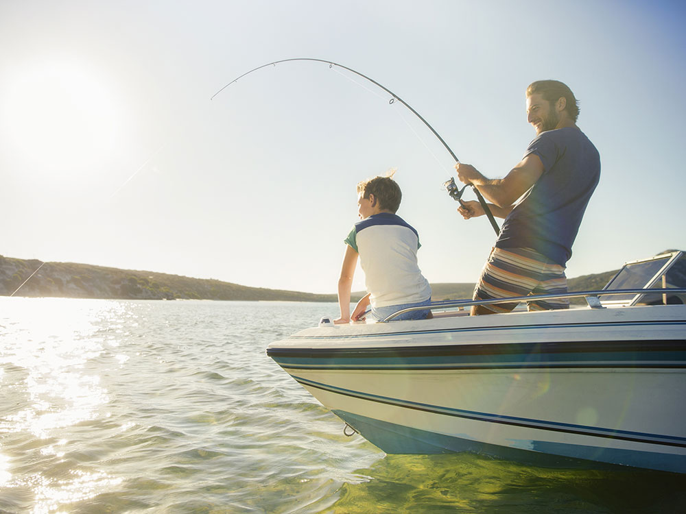 Two guys fishing on a boat.